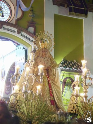Antes de entrar en la capilla la Virgen es recibida en la puerta con una lluvia de ptalos, el repique de campanas y una gran traca de cohetes 