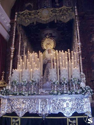 La Santsima Virgen de la Esperanza desfila bajo palio verde bordado en oro por D. Juan Castilla Romero que lo termin para su desfile el 27 de Febrero de 1.955 